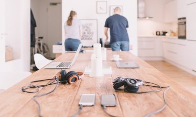 Portátiles, móviles y auriculares sobre la mesa de una cocina en una casa donde se teletrabaja