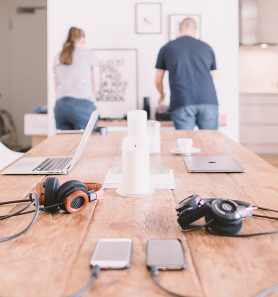 Portátiles, móviles y auriculares sobre la mesa de una cocina en una casa donde se teletrabaja